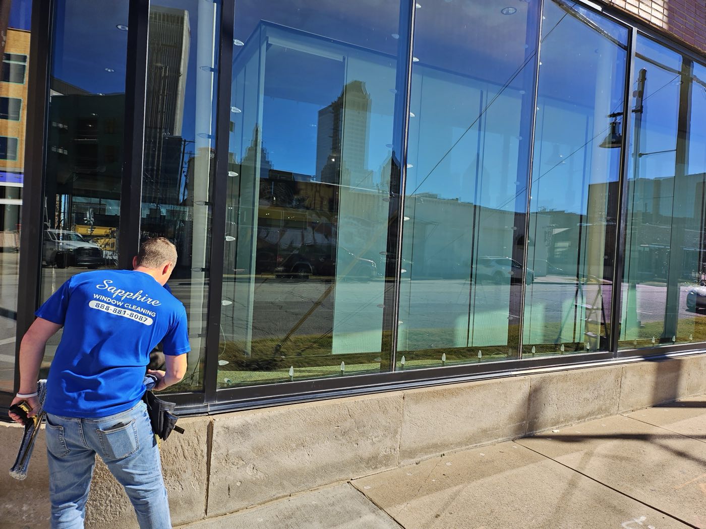 A Sapphire technician cleaning storefront windows